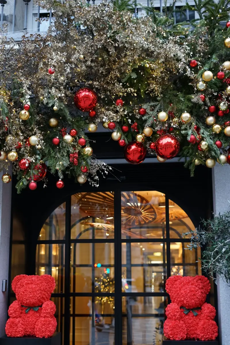 Storefront windows decorated with holiday garland and gifts